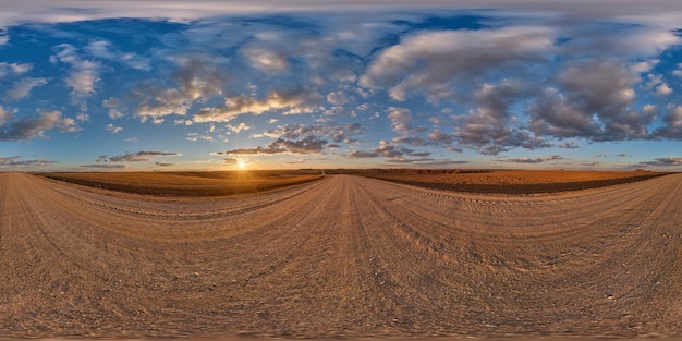 Panorama 360 hdri na estrada de cascalho com nuvens noturnas no céu azul antes do pôr do sol em uso de projeção esférica equiretangular sem costura como substituição do céu no desenvolvimento de jogos de panoramas de drones como cúpula do céu