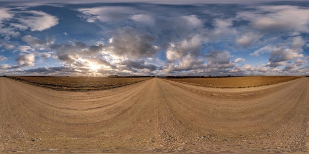 Panorama 360 hdri na estrada de cascalho com nuvens noturnas no céu azul antes do pôr do sol em uso de projeção esférica equiretangular sem costura como substituição do céu no desenvolvimento de jogos de panoramas de drones como cúpula do céu