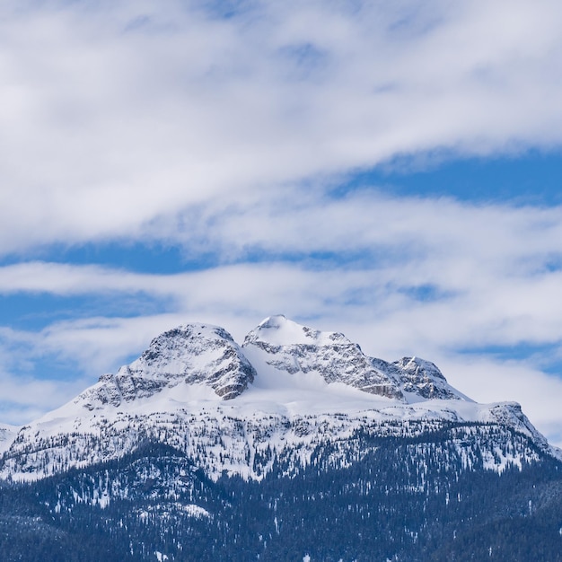 Panorama de altas montañas cubiertas de nieve cielo azul nublado columbia británica canadá