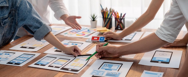 Panorama-Aufnahme des Frontend-Entwicklerteams beim Brainstorming von UI- und UX-Designs für mobile Apps auf Papier Wireframe-Schnittstelle Benutzeroberfläche Entwicklungsteam Planung für benutzerfreundliches UI-Design Überprüfen