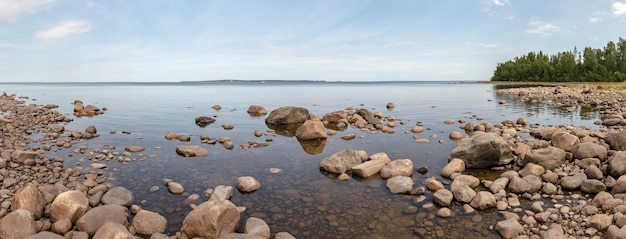 Panorama de la bahía del lago Ladoga en la parte europea de Rusia con árboles de piedras y aguas tranquilas
