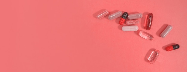Panorama bunte Pillen und Kapseln auf rosa Hintergrund