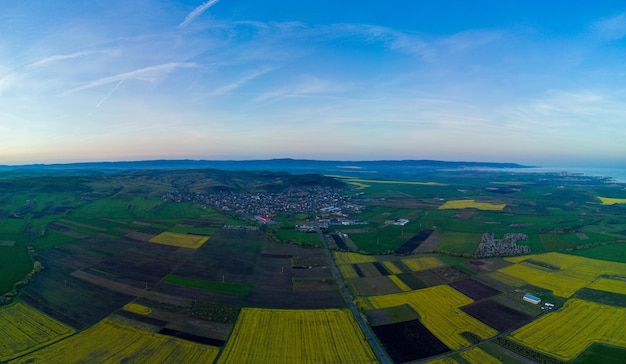 Foto panorama de los campos con una planta en un valle contra la perspectiva del pueblo y el cielo en bulgaria