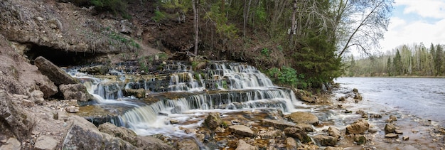 Panorama de la cascada que emana de debajo del suelo en el río Poneretka