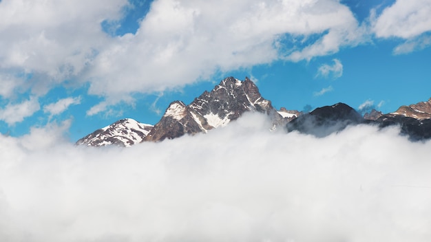 Panorama de la cima de la montaña que sale de las nubes