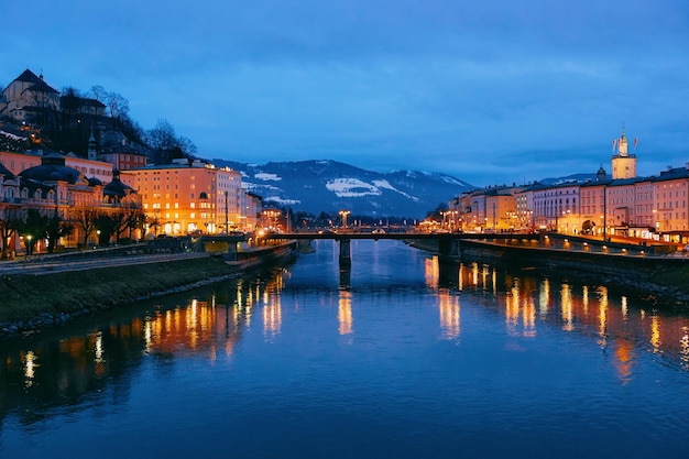 Panorama de la ciudad vieja de Salzburgo y el puente sobre el río Salzach en Austria por la noche. Paisaje y paisaje urbano de la ciudad de Mozart en Europa en invierno por la noche. Vista panorámica de la antigua calle de la ciudad austriaca.