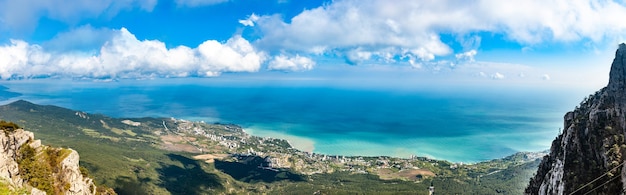 Panorama de colinas y montañas y un pueblo costero ubicado cerca del mar azul