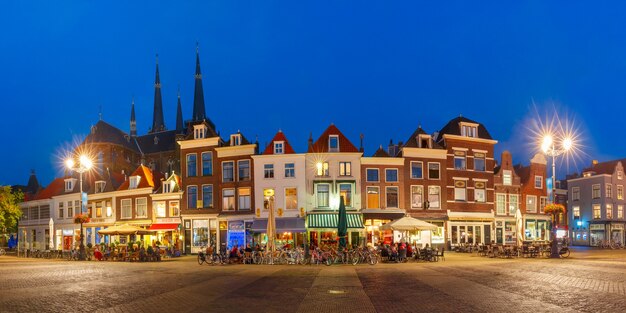 Panorama com casas típicas holandesas na praça Markt, no centro da cidade velha à noite, e Maria van Jessekerk ao fundo, Delft, Holanda, Holanda