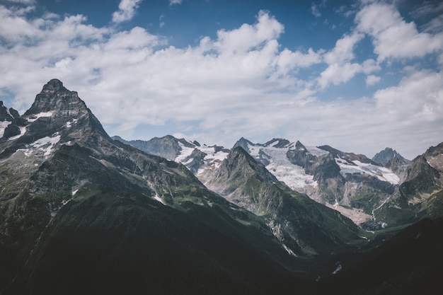 Panorama da cena de montanhas com céu azul dramático no Parque Nacional de Dombay, Cáucaso, na Rússia. Paisagem de verão e dia ensolarado