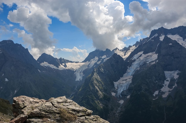 Panorama da cena de montanhas com céu azul dramático no parque nacional de dombay, cáucaso, na rússia. paisagem de verão e dia ensolarado