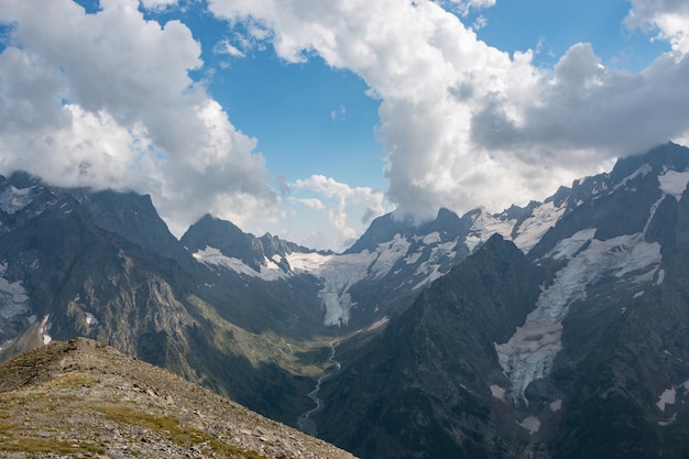 Panorama da cena de montanhas com dramático céu nublado no parque nacional de dombay, cáucaso, rússia. paisagem de verão e dia ensolarado