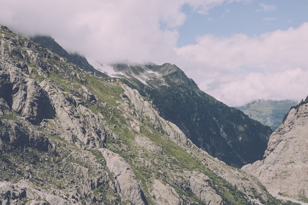 Panorama da cena de montanhas na rota de Trift Bridge no Parque Nacional da Suíça, Europa. Céu nublado dramático e paisagem ensolarada de verão