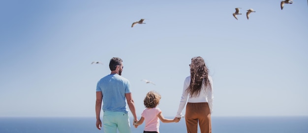 Panorama da família linda e feliz com crianças caminhando juntos na praia do mar durante as férias de verão fr