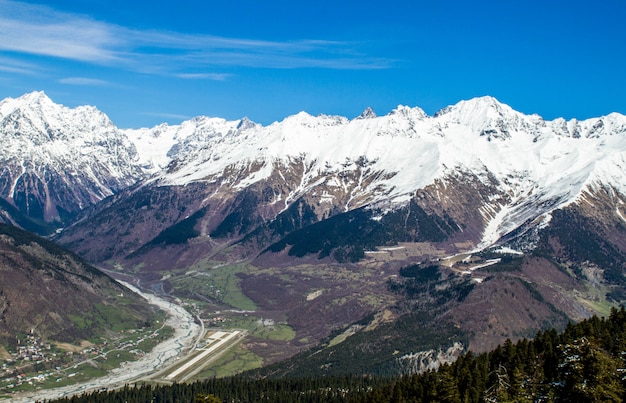 Foto panorama da vila da geórgia nas montanhas rio e neve