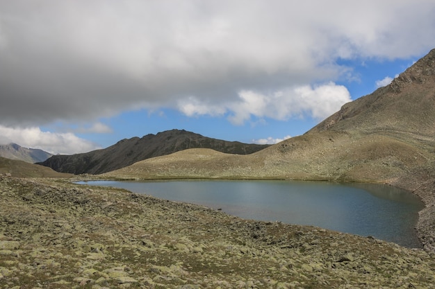 Panorama das cenas do lago nas montanhas, Parque Nacional Dombay, Cáucaso, Rússia, Europa. Céu azul dramático e paisagem ensolarada em dia de verão