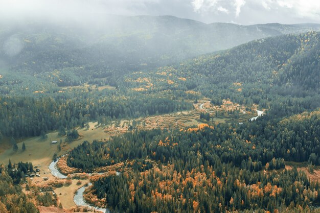 Panorama das encostas da montanha em cores de outono e o vale do rio, fundo natural de outono. Vista aérea.