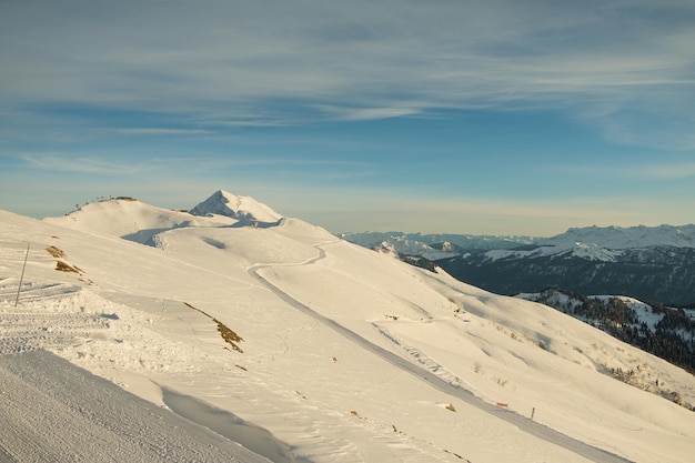 Panorama das montanhas de inverno com pistas de esqui e elevadores de esqui em uma estância de esqui de dia ensolarado elevando as montanhas