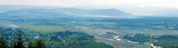 Panorama de aldeia de montanha de manhã nublada de verão (paisagem rural). Três tiros costuram a imagem.