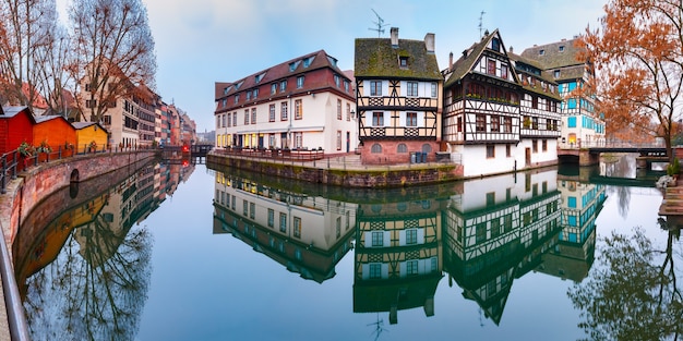 Panorama de casas de enxaimel tradicionais da Alsácia com reflexos no espelho na Petite France pela manhã, Estrasburgo, Alsácia, França