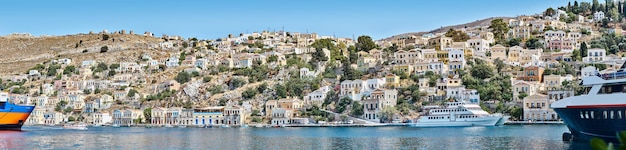 Panorama de casas multicoloridas nas colinas da cidade costeira da ilha de Symi, na Grécia