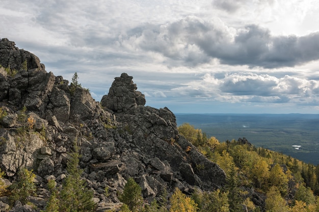 Panorama de cenas de montanhas no Parque Nacional Kachkanar, Rússia, Europa. Tempo nublado, céu azul dramático, árvores verdes distantes