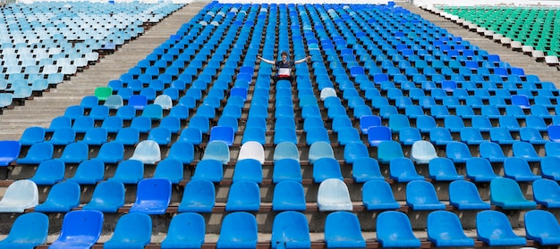 Panorama de enormes assentos de estádio com um homem assistindo aos shows de eventos musicais