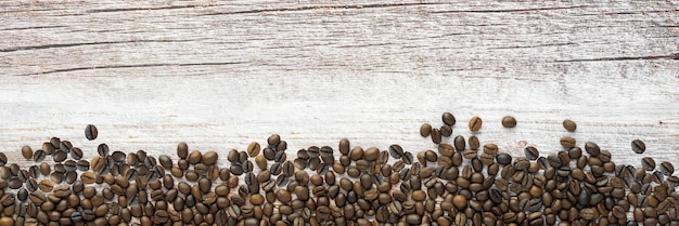 Panorama de grãos de café na textura de madeira
