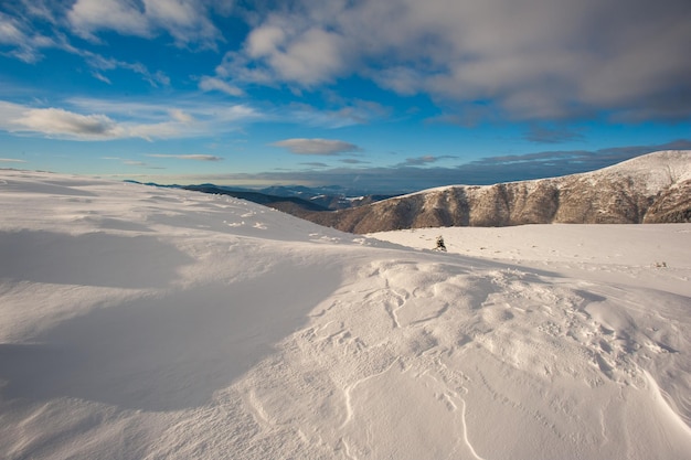 Panorama de montanhas cobertas de neve, neve e nuvens no horizonte