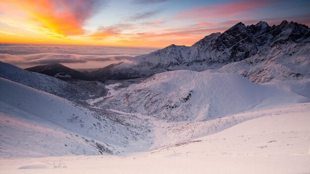 Panorama de montanhas nevadas no inverno ao nascer do sol