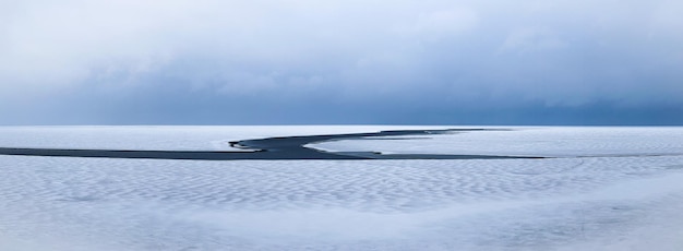 Panorama de um belo lago enorme em um dia nublado A superfície do lago com uma rachadura na água