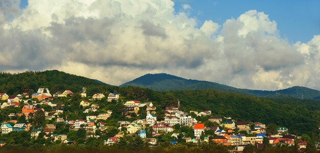 Panorama de uma área residencial nas montanhas contra um céu azul com nuvens à noite