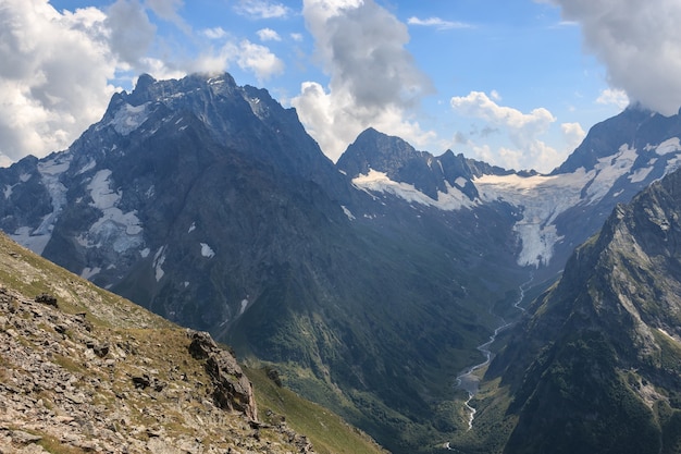 Panorama der Bergszene mit dramatischem blauem Himmel im Nationalpark von Dombay, Kaukasus, Russland. Sommerlandschaft und sonniger Tag