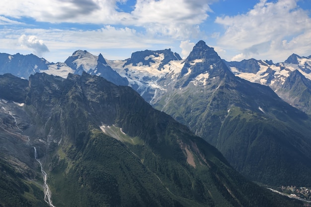 Panorama der Bergszene mit dramatischem blauem Himmel im Nationalpark von Dombay, Kaukasus, Russland. Sommerlandschaft und sonniger Tag