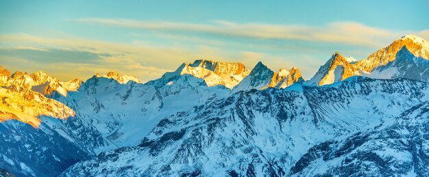 Panorama der hohen Berggipfel bei Sonnenuntergang. Landschaft auf Schneehügeln