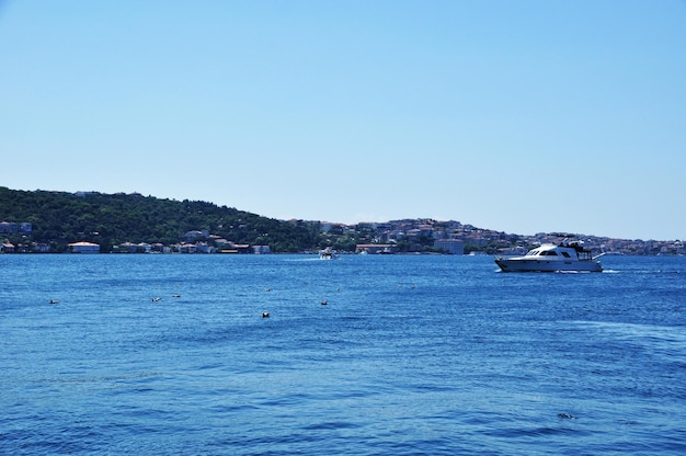 Panorama der Meerenge und Küste. Das Ausflugsboot segelt auf der ruhigen See.