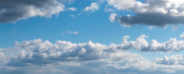 Panorama des blauen Himmels mit weißen lockigen Wolken