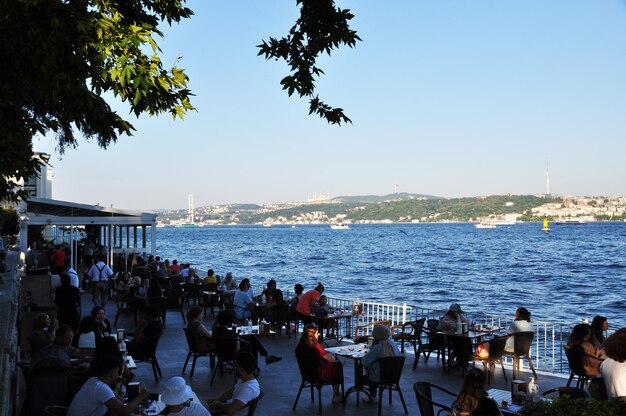 Panorama des Bosporus. Blick auf das überfüllte Café am Ufer der Meerenge. Küstenansicht.