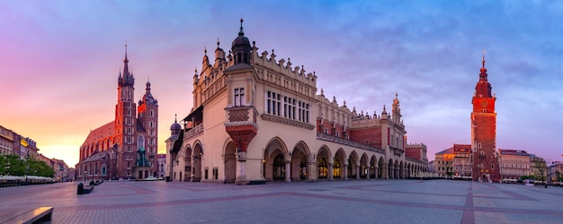 Panorama des mittelalterlichen Hauptmarktplatzes mit Basilika der Heiligen Maria, Stoffhalle und Rathaus-Turm in der Altstadt von Krakau bei Sonnenaufgang