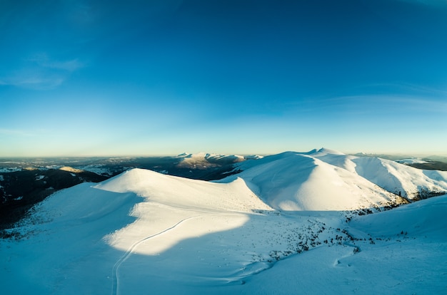 Panorama de día maravilloso de ventisqueros en las montañas entre los bosques en un soleado día de niebla helada. El concepto de naturaleza virgen de la naturaleza del norte