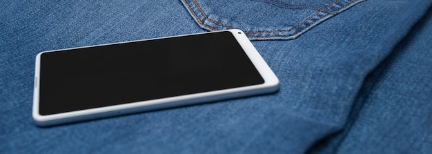 Panorama do celular branco em jeans azul