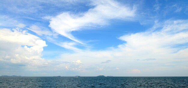 Panorama do céu azul com nuvens brancas e mar