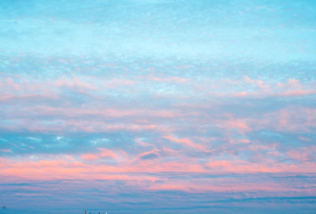 Panorama do céu com nuvens cor de rosa ao pôr do sol ou nascer do sol fundo abstrato com nuvens de cores roxas e azuis rosa nuvens rosa claras no céu azul do pôr do sol cores pastel das nuvens ao pôr do sol do nascer do sol