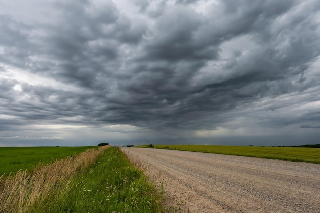 Panorama do fundo do céu negro com nuvens de tempestade frente de trovão sobre estrada de cascalho