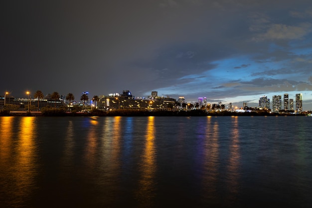 Panorama do horizonte da cidade de Miami à noite de Miami com arranha-céus urbanos sobre o mar com reflexão