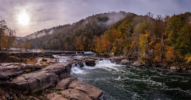 Panorama do Valley Falls State Park, perto de Fairmont, na Virgínia Ocidental, em um colorido dia de outono enevoado com cores de outono nas árvores