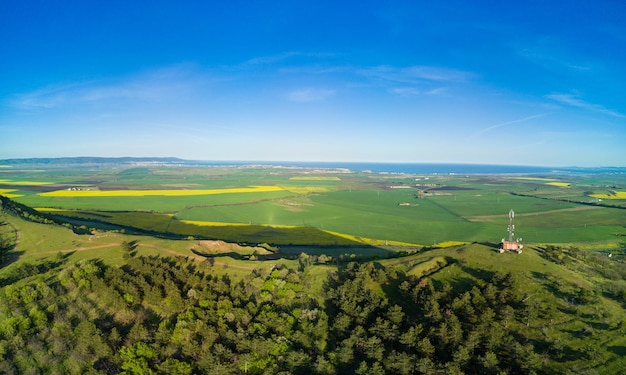 Panorama dos campos com uma planta em um vale no contexto da vila e do céu na bulgária