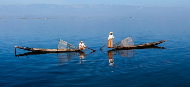 Panorama dos pescadores birmaneses tradicionais com rede de pesca no lago Inle, em Mianmar, famoso por seu estilo distinto de remo com uma perna