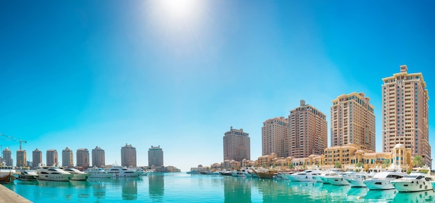 Panorama de edificios residenciales de lujo de Pearl Qatar y yates blancos en el puerto deportivo de Porto Arabia Doha Qatar