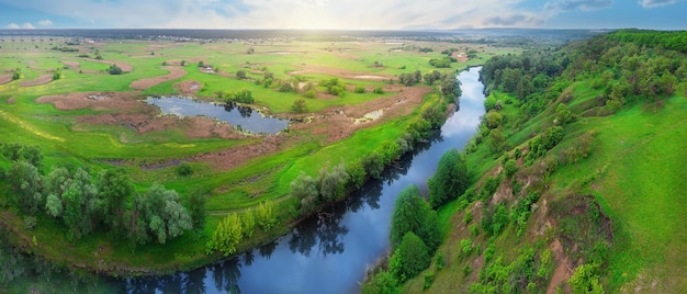 Panorama eines Flusses, der in ein grünes Tal fließt