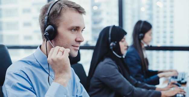 Panorama del equipo diverso del personal de servicio al cliente de telemarketing del grupo en el centro de llamadas. Trabajador de call center acompañado de equipo. Sonriendo del operador de soporte al cliente en el trabajo.